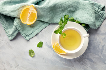 A cup of green tea with lemon and mint leaves, shot from the top with copy space © laplateresca