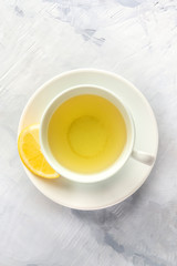 A photo of a cup of green tea with lemon, shot from the top with copy space