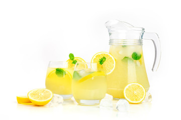 A side view of homemade lemonade in glasses and a pitcher, with fresh lemons and mint, on a white background with a place for text