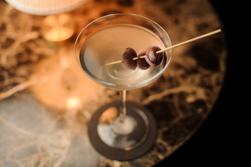 Close-up of alcohol cocktail with olives on the table