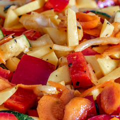 Raw fresh vegetables cut for further processing, mixed and topped with an oily spice mixture.