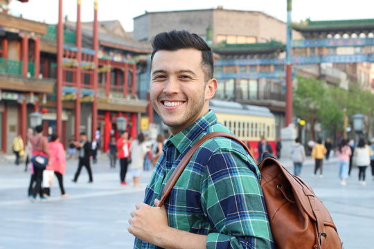 Cute young man smiling in Asian crowded street 