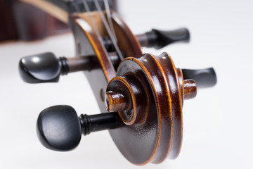 Scroll of the classical violin on white background. Head of vintage violin over white background