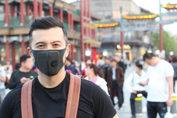 Fototapeta na wymiar Man with pollution mask standing out from the crowd 