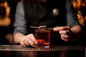 Close shot of an alcohol cocktail with chocolate in bartender's hands