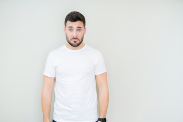 Young handsome man wearing casual white t-shirt over isolated background depressed and worry for distress, crying angry and afraid. Sad expression.