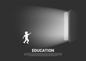 Silhouette of running boy point to light from open book. Concept of education solution. world of knowledge.