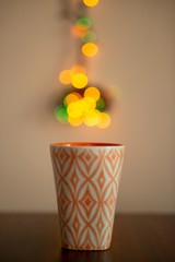 orange cup of coffee with colorful bokeh steam