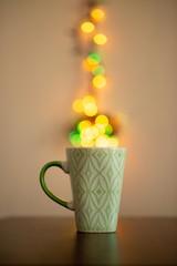 green cup of coffee with colorful bokeh steam