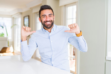 Handsome hispanic business man looking confident with smile on face, pointing oneself with fingers...