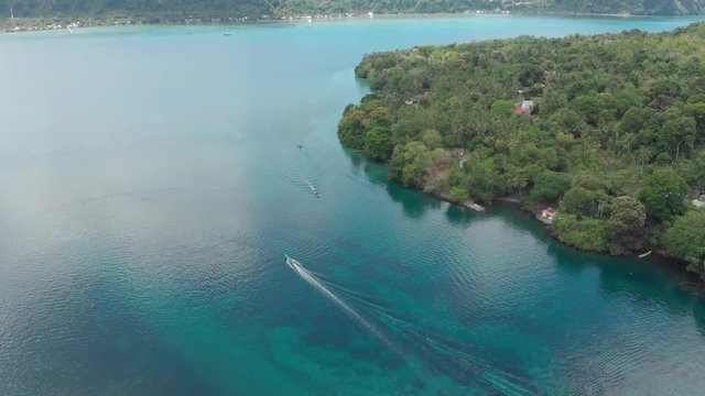 Aerial: flying over Bandaneira village tourist resorts bungalow coastline Indonesia Banda Islands Maluku, diving travel destination, old dutch colony for nutmeg. Native cinelike D-log color profile