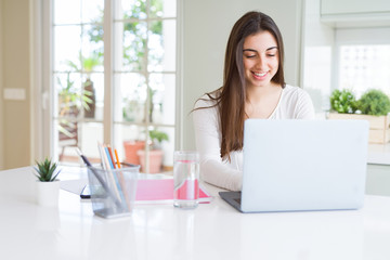 Young beautiful woman smiling happy and working using computer laptop