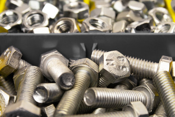 Fototapeta na wymiar closeup new bolts and nuts sorted in container shot