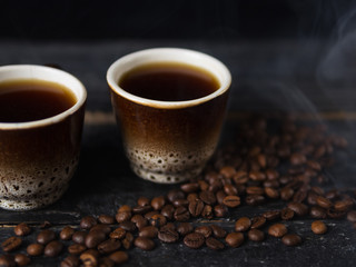 fragrant espresso coffee with steam on wood.