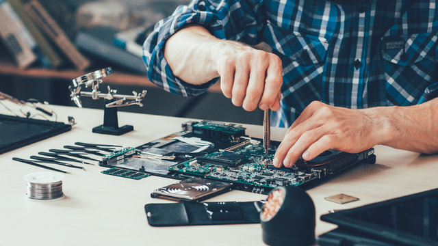 Computer repair technician working on motherboard