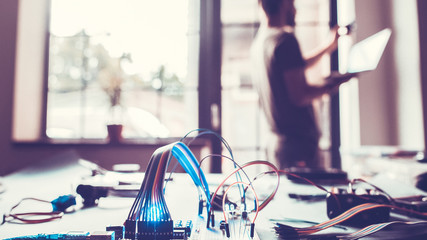 Smart home system installation. Technician connecting computer to house. Programmer using computer technology for automation.