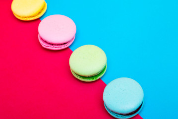 Assortment of macarons on red - blue background 
