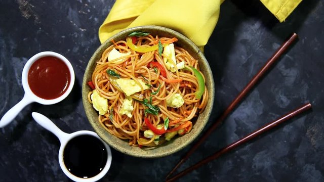 video/footage of Egg Schezwan/hakka noodles, popular indochinese food served in a bowl with chopsticks. selective focus