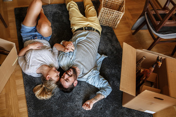 Couple moving into new home.They lying on carpet and relaxing after unpacking.