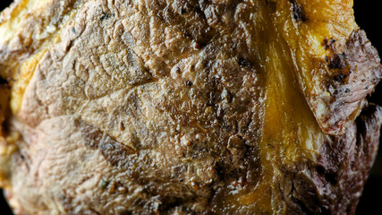 Grilled steak female fingers are held full length on an isolated black background clous-up