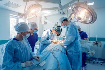 Spinal surgery. Group of surgeons in operating room with surgery equipment. Laminectomy
