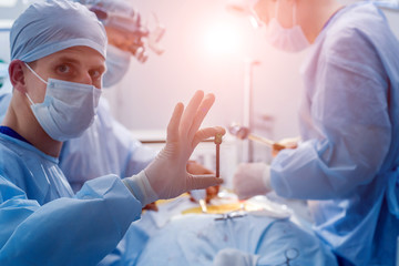 Spinal surgery. Group of surgeons in operating room with surgery equipment. Laminectomy