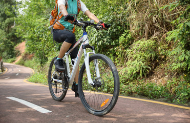 Woman riding Mountain Bike on forest trail