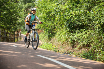 Fototapeta na wymiar Woman cyclist riding Mountain Bike on forest trail