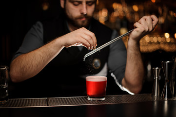 Fototapeta na wymiar Bartender making an alcohol cocktail using a grater