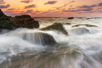 Obraz premium Beautiful natural seascape wave hit the rock during sunset