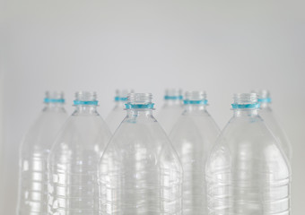 Bottlenecks of a pack of liter and a half of empty mineral water without caps just with the sealing ring on a white background. Reuse, Eco-Friendly, Environment, Conservation, Sustainable.
