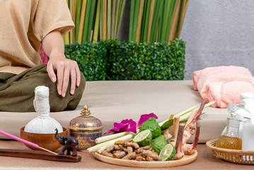 Thai Masseuse doing massage for lifestyle woman in spa salon. Asian beautiful woman getting Thai herbal massage compress massage in spa.She is very relaxed. Healthy Concept.