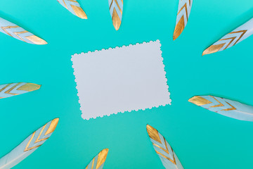 Fototapeta premium scattered decorative feathers and space for inscription. on blue background