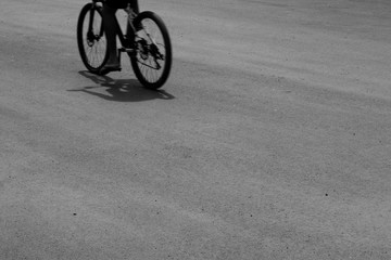 Fototapeta na wymiar Black and white a bicycle against shadow on asphalt road
