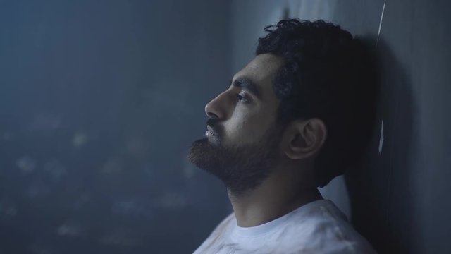 A sad oppressed young man in prison