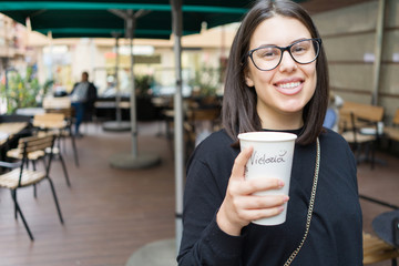 Beautiful young woman smiling cheerful enjoying sunny day drinking a take away cup of coffee