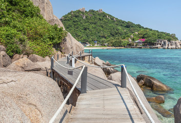Obraz premium Landscape view of old wooden walkway bridge through the rock at Koh Nang Yuan Island under blue sky in summer day Koh Nang Yuan Island is most popular famous tourist attractions in the gulf of Thailan