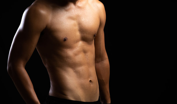 Closeup of a strength fitness body. Fit young man with beautiful torso. Beginner Bodybuilder and muscular body concept.