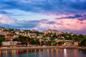 Panoramic view of Ulcinj at sunset, beautiful mediterranean town, popular summer tourist resort in Montenegro, scenic travel background with urban architecture, sand beach and dramatic cloudy sky
