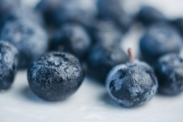 fresh blueberry berries on a white plate close-up. breakfast of wild berries. copy space