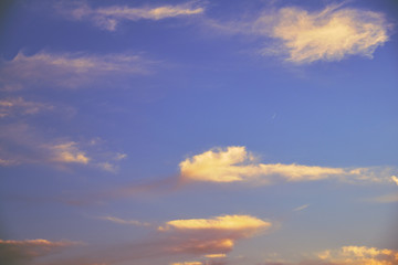 Beautiful blue sky with clouds during sunset and a young moon.