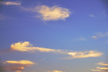 Fototapeta premium Beautiful blue sky with clouds during sunset and a young moon.