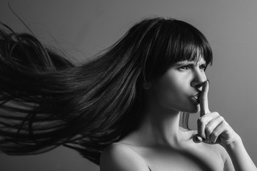 Professional care. Black and white closeup portrait of emotional brunette girl found a secret of hair treatment. Beauty studio.