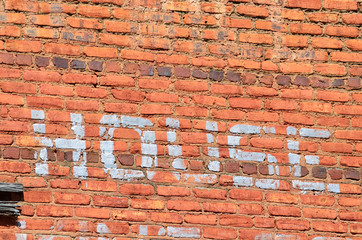 The word 'house' from sign painted on old brick building