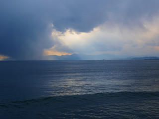 Sea where sunlight falls from cloudy sky