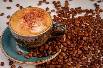 cup of coffee with beans on white background