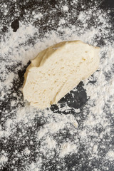 Raw cut dough lies on the table with flour before cooking cottage cheese cookies