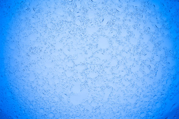 Rain droplets on blue glass background, Water drops on blue glass.
