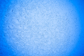 Rain droplets on blue glass background, Water drops on blue glass.