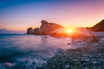 Poster Aphrodite's Rock beach, Petra tou Romiou, the birthplace of Goddness Aphrodite, Paphos, Cyprus. Amazing sunset seascape of Love beach with rocks and sea pebbles, travel background, tourist location © larauhryn